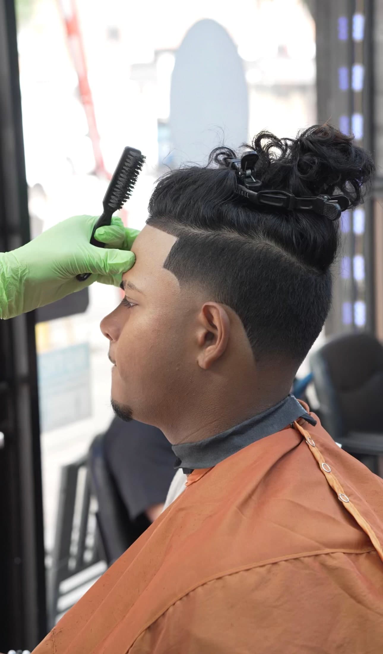 Textured fade with man bun styled at Traggocuts